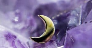 This image showcases a gold crescent moon stud, beautifully set against a purple amethyst crystal background, creating a celestial and mystical aesthetic. Key Features: Material: High-polish gold (or gold-plated finish). Design: Minimalist crescent moon shape. Vibe: Celestial-inspired jewelry perfect for: Helix Tragus Conch Flat piercings. The pairing of the luminous gold moon with the amethyst highlights its ethereal, dreamy quality — perfect for those who adore nature and celestial-inspired piercings.