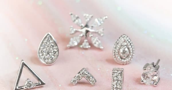 This image highlights a dazzling collection of diamond-adorned silver jewelry studs, each offering unique designs for a sophisticated, high-end look: Featured Styles: Snowflake Design – Perfect for a statement piece. Teardrop Pave Studs – Elegant and versatile for a timeless appeal. Triangle & Chevron Studs – Modern geometric style for minimalists. Bar & Round-Cut Solitaire – Classic designs for a refined finish. Ideal for: Helix Piercings Tragus Flat Lobes Each stud offers versatility, catering to both subtle aesthetics and bold statement wear.