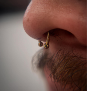 Man with septum gold piercing jewelry